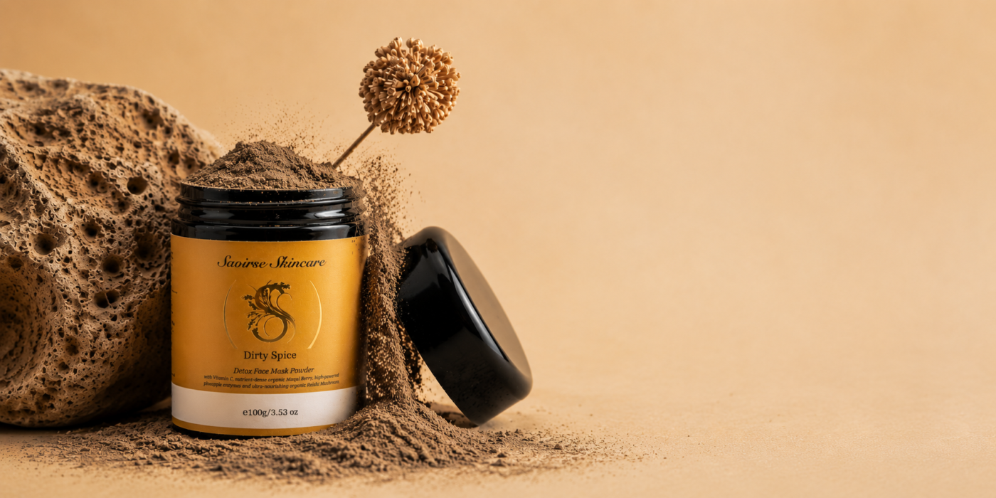 Jar of Saoirse Skincare Dirty Spice detox face mask powder, with powder spilling around it against a beige background.