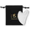 Silver heart-shaped facial massager resting against a black drawstring pouch with the Saoirse Skincare logo in gold wheels.